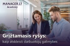 Vadovė teikia darbuotojui pozityvų grįžtamąjį ryšį prie stalo su laptopu