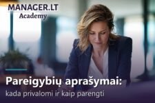 Vadovė biure prie stalo pasirašo darbuotojo pareigybės aprašymą